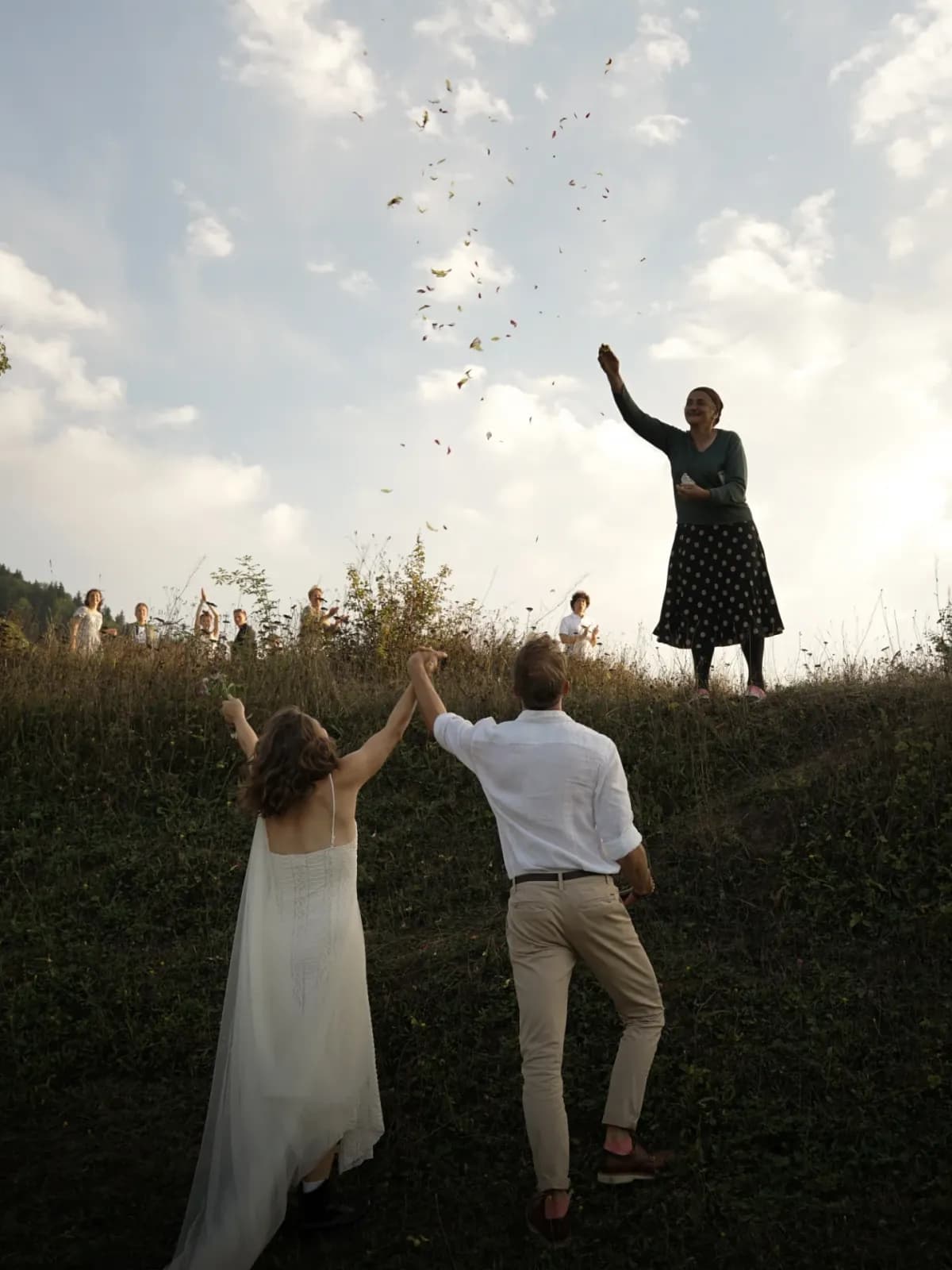 The couple celebrating in the meadow, petals in the air