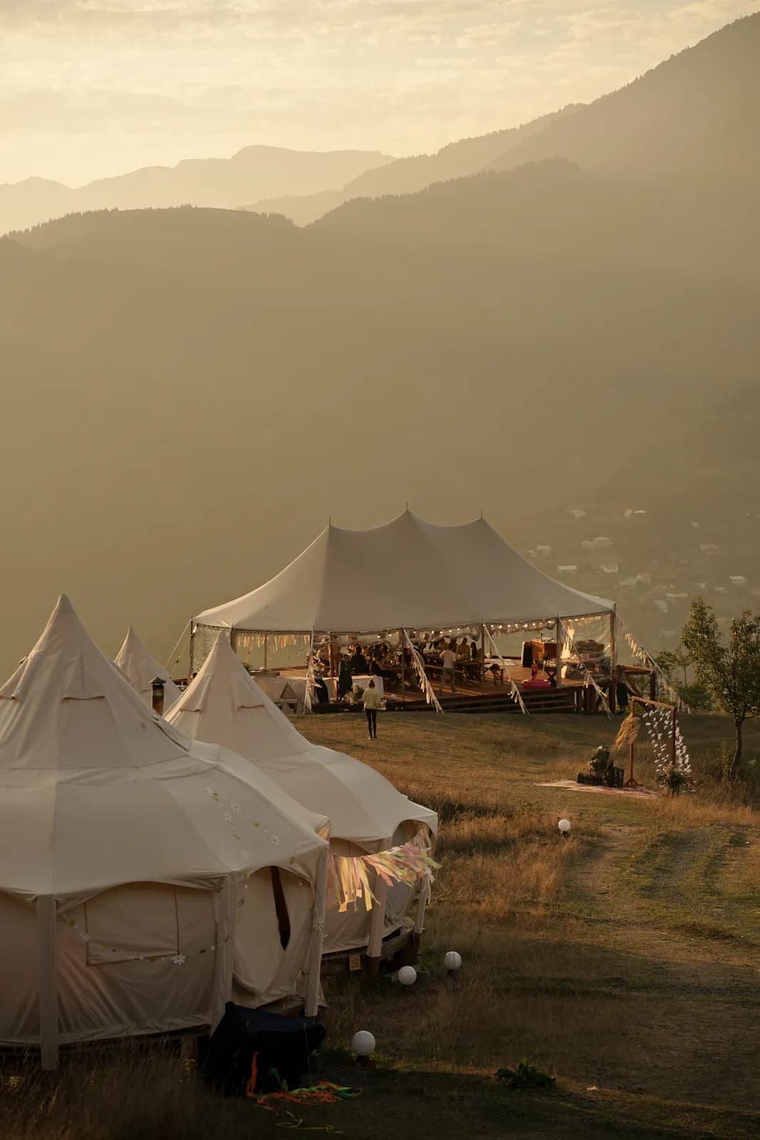 The wedding tent and bell tents at dusk