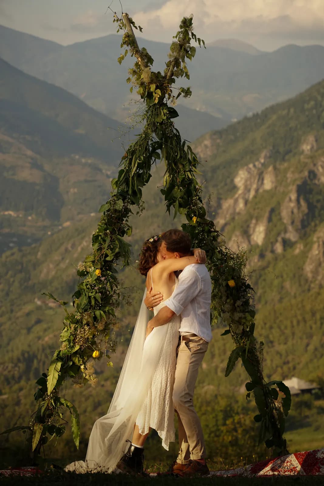 The couple kissing under the arch above the valley