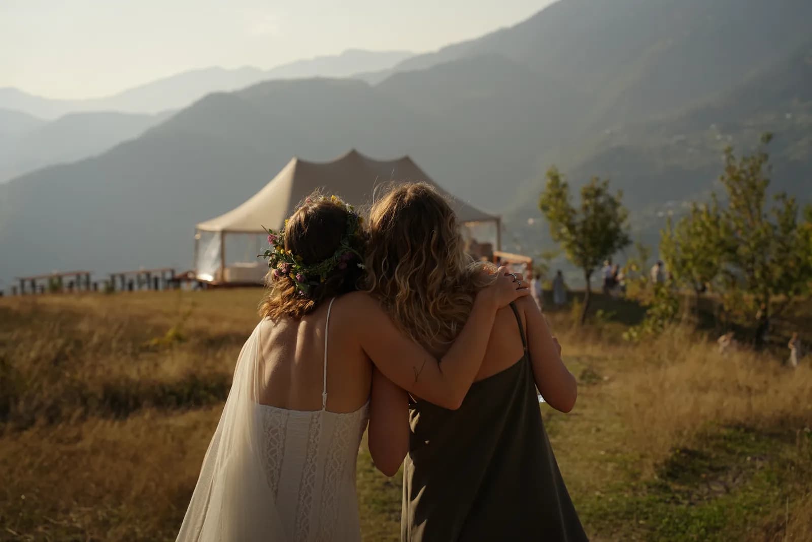 Bride and her friend walking toward the wedding tent